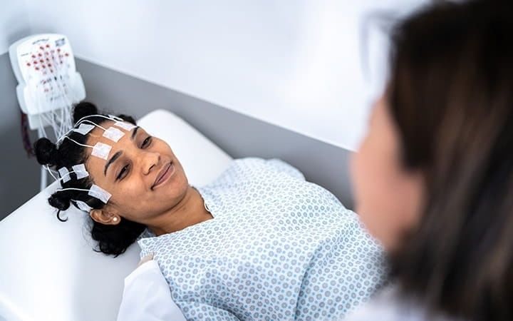 Schlafende Patientin mit Elektroden zur Messung der Gehirnaktivität